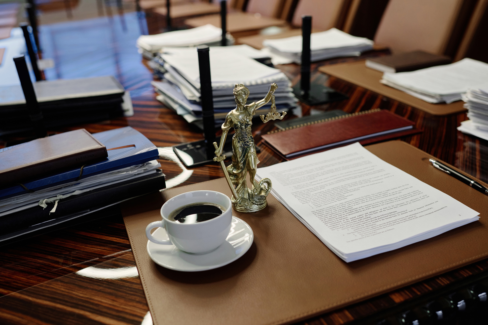 Lady Liberty on the Conference Room Table of Corporate Lawyers doing Business Law with Coffee and Documents